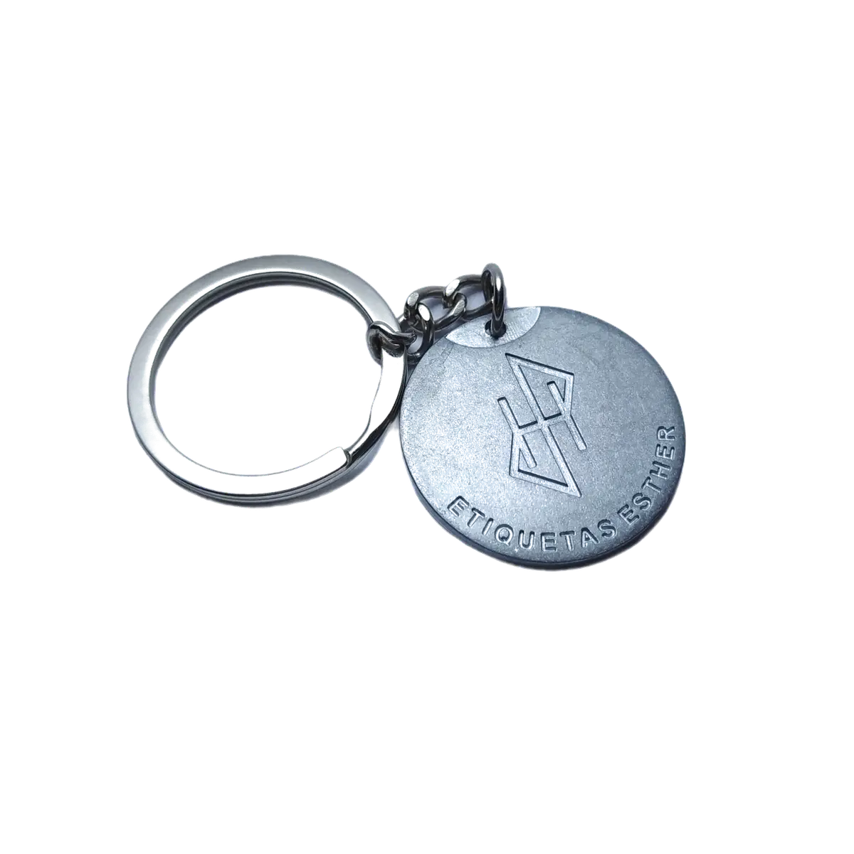 Llavero de zamak con medalla redonda en níquel brillante sobre fondo oscuro